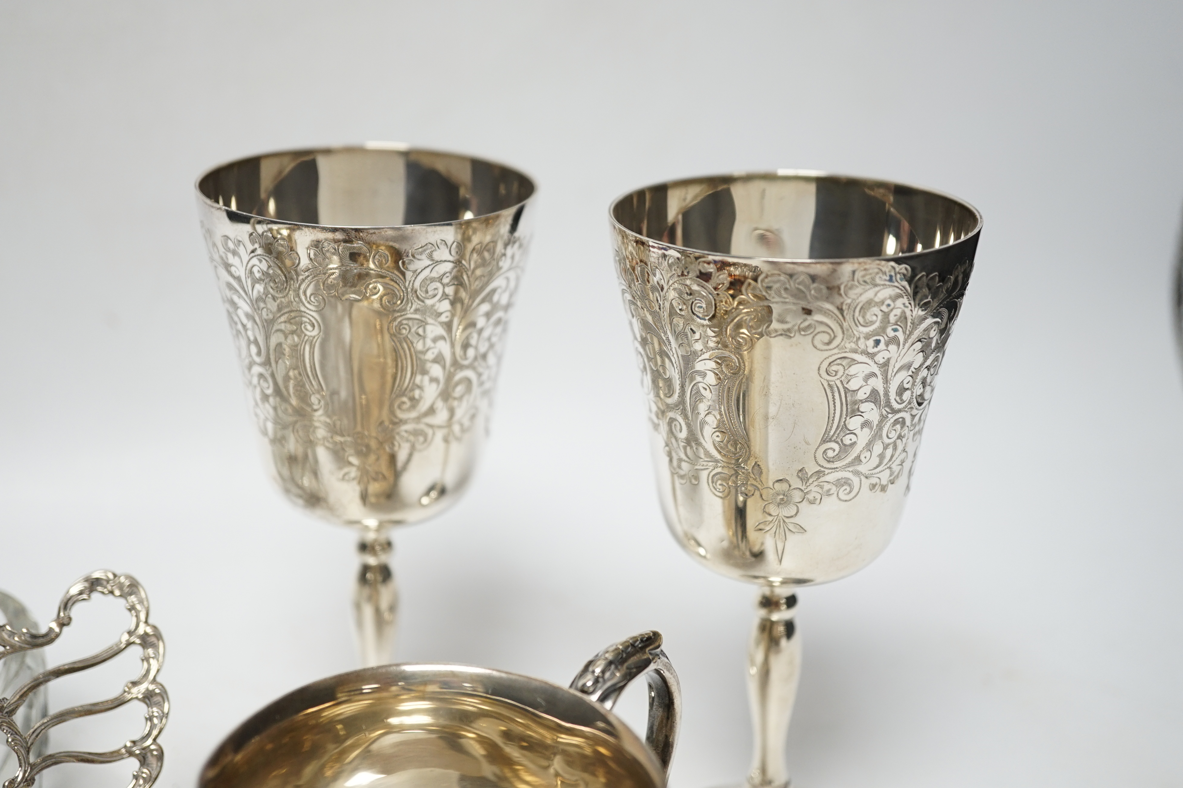 A George V silver christening mug, with card cut decoration, Adie Bros. Birmingham, 1903, height 81mm, a silver sauceboat, a dish, a pair of modern silver goblets and a 1970's silver mounted glass 'swan' bonbon dish.